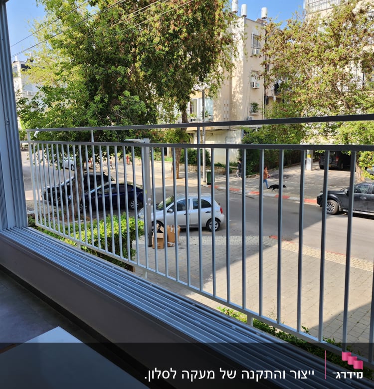 מעקה מתכת לבן במרפסת עם נוף לרחוב